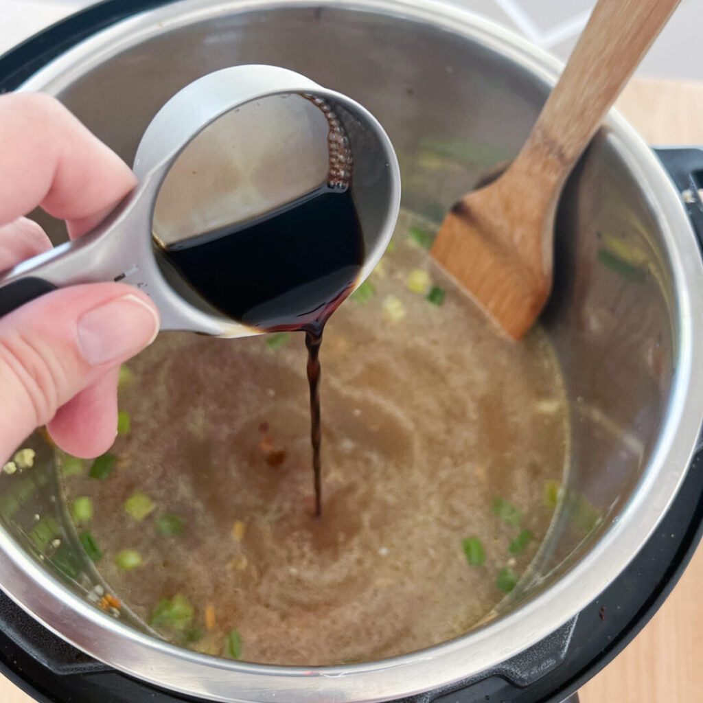 Soy Sauce poured into Instant Pot Ramen