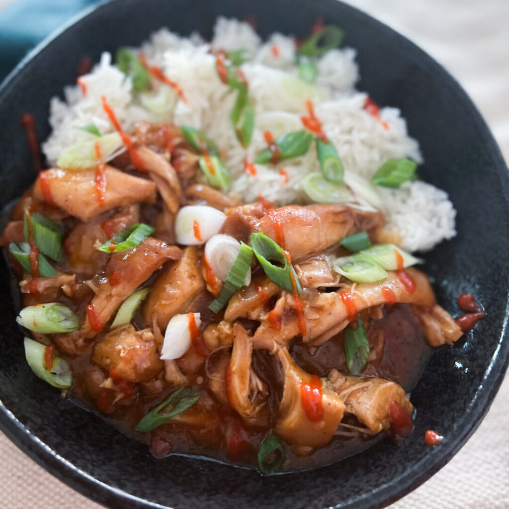 Bourbon chicken with rice on a black bowl