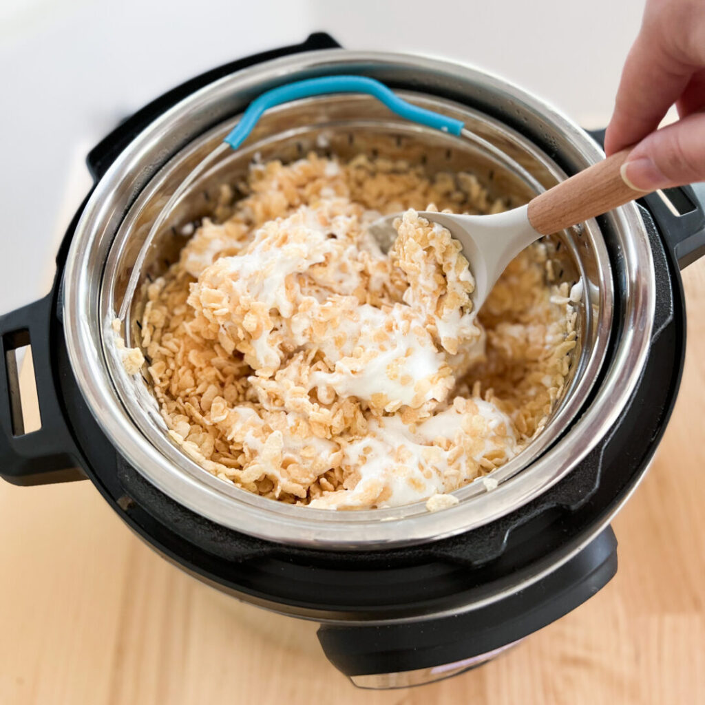 Rice crispy treats and marshmallows being stirred in an Instant Pot