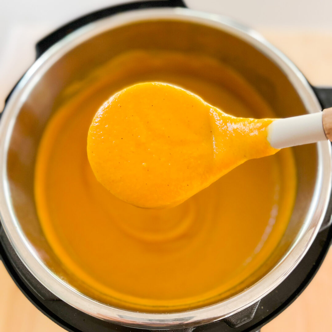 Butternut squash soup in a spoon over an Instant Pot