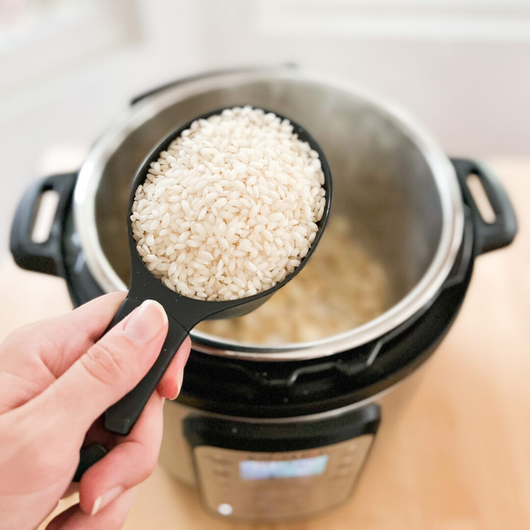 Arborio rice in a measuring cup over an Instant Pot