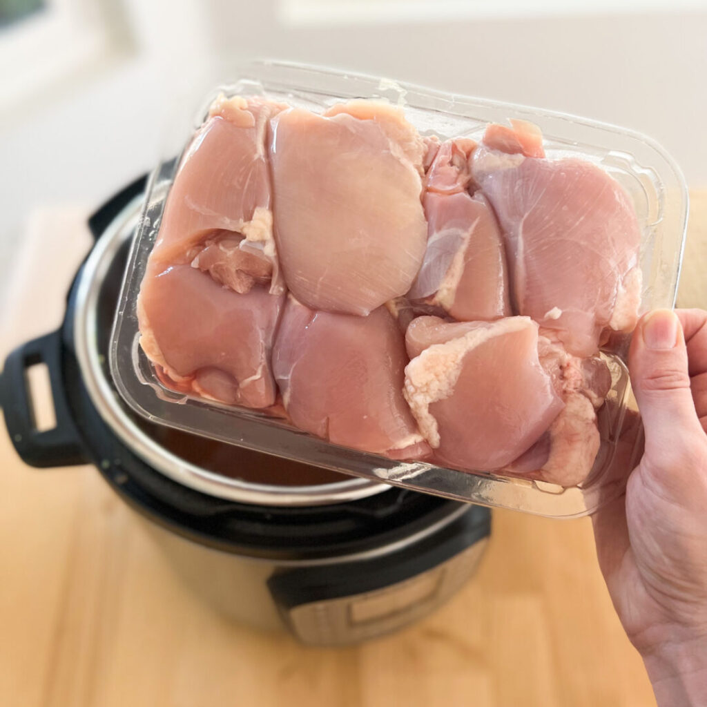 Chicken thigh carton over an Instant Pot.