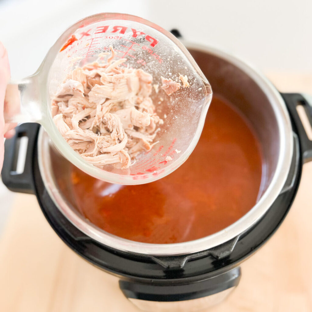 Shredded chicken over an Instant Pot.