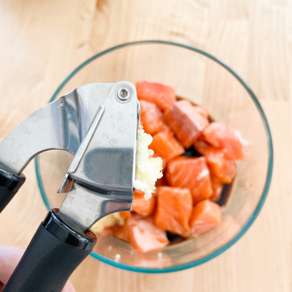 Garlic press over salmon.