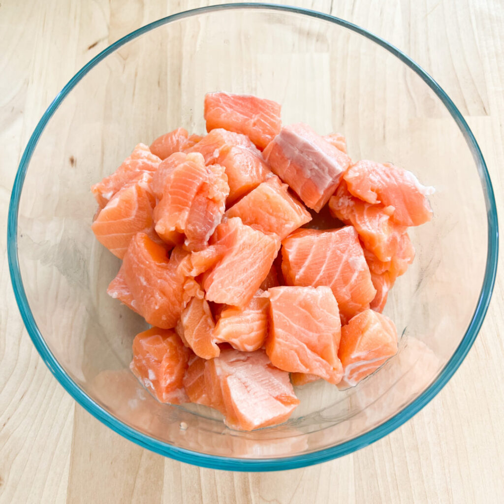 Salmon cut in cubes in a bowl.