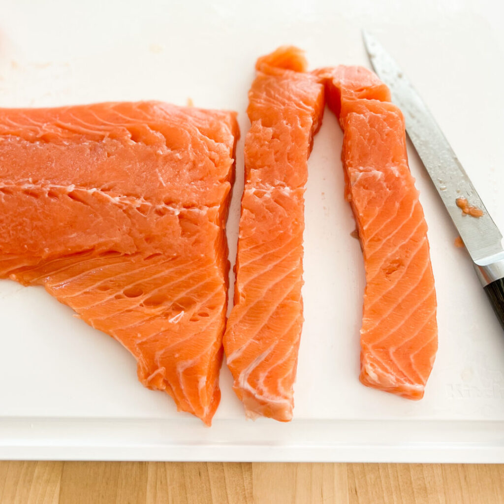 Salmon being cut into strips.