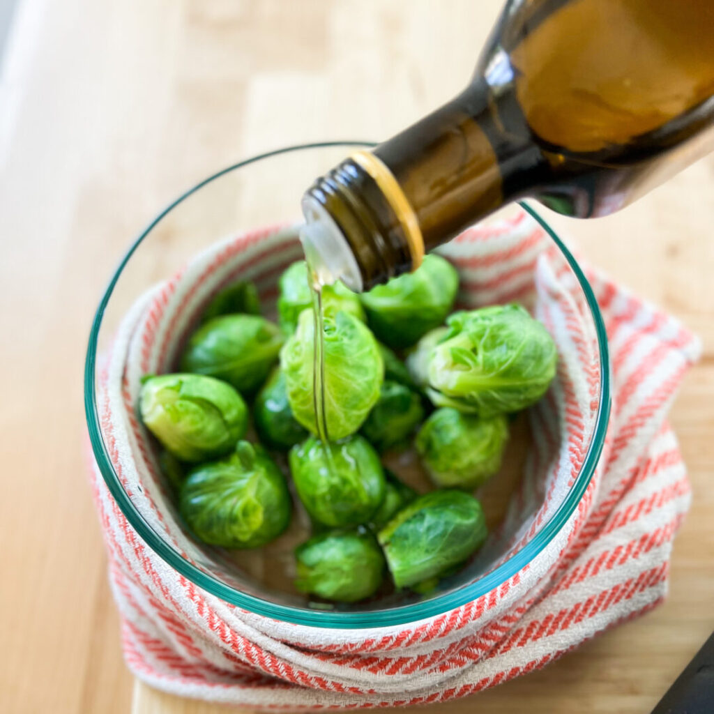 Oil poured over brussels sprouts.