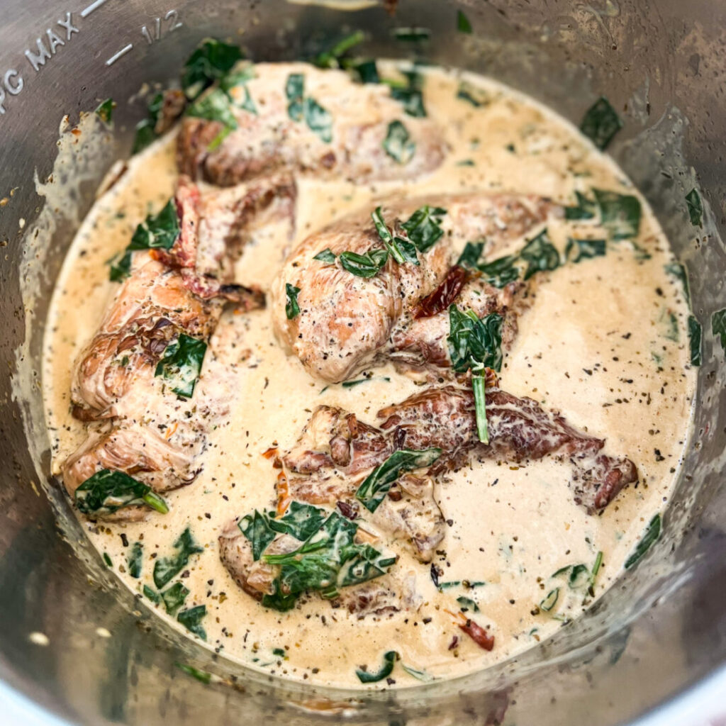 Instant Pot chicken, veggies, and seasoning mixed together.