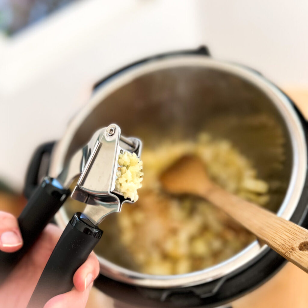 Adding garlic to Instant Pot.
